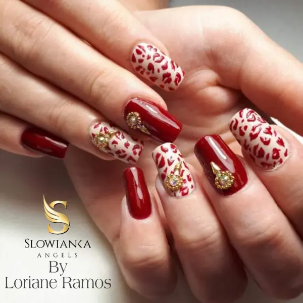 Manucure ongles longs effet léopard rouge et crème avec strass dorés. Texte : Slowianka Angels By Loriane Ramos.